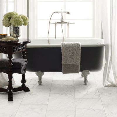 marble tile floors in an elegant black and white bathroom with tub and large window